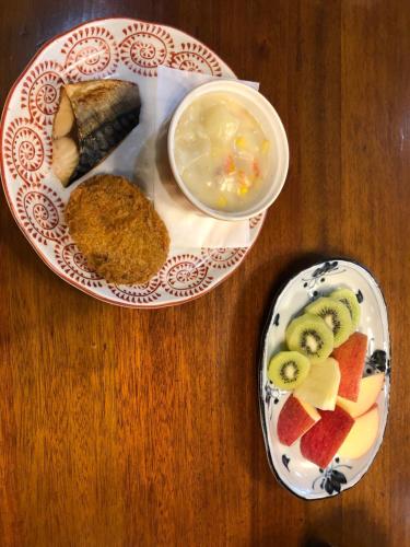 a wooden table with two plates of food on it at Uchihan in Nozawa Onsen