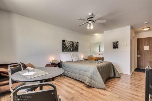a bedroom with a bed and a table and a ceiling fan at Auberge motel drakkar in Shawinigan