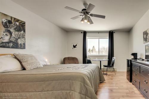 a bedroom with a bed and a ceiling fan at Auberge motel drakkar in Shawinigan