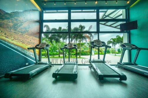 a gym with three treadles in front of a window at NN Famille Guest House in Pasir Gudang