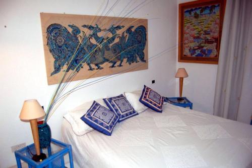 una camera da letto con un letto con cuscini blu e bianchi di Apt. Marilena by SolturElba a Capoliveri