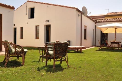 two chairs and a table and an umbrella in a yard at Lanita B&B in Càbras