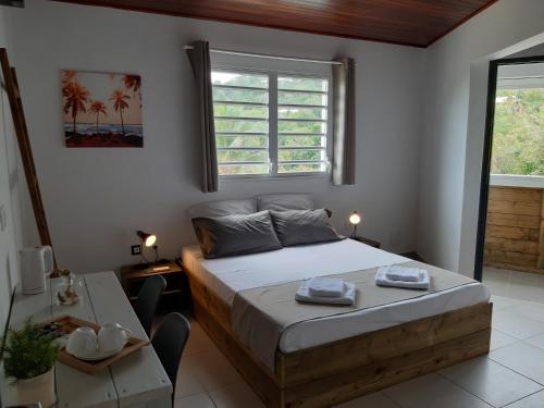 a bedroom with a bed and a table and a window at Villa Clémence in Le François
