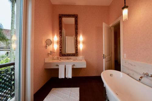 a bathroom with a large mirror and a tub at Hotel Reggia Catarina in Petrópolis