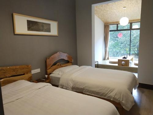 a bedroom with two beds and a window at Nirvana Organic Farm Inn in Yangshuo