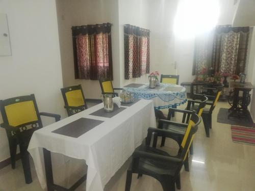 a dining room with a white table and chairs at Takashi Homestay North Paravur Near Muziris in North Paravur