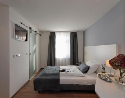 una camera con un grande letto e una finestra di Schlotzeria Hotel I Café I Eis a Grenzach-Wyhlen