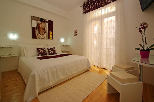 een witte slaapkamer met een bed en een raam bij B&B Vela Luka in Vela Luka