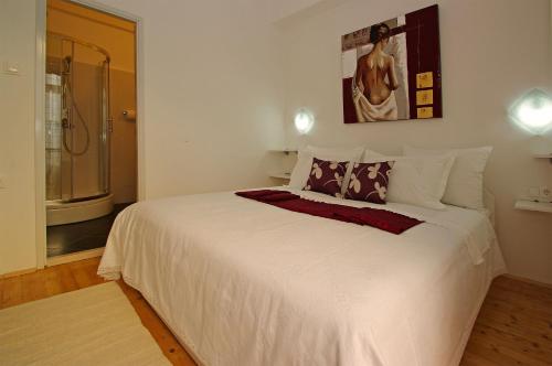 a bedroom with a large white bed and a bathroom at B&B Vela Luka in Vela Luka