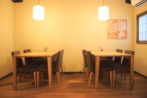 a dining room with two tables and chairs and lights at K's House Takayama [1st K's Hostel] in Takayama