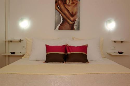 a bed with two pillows and a painting on the wall at B&B Vela Luka in Vela Luka