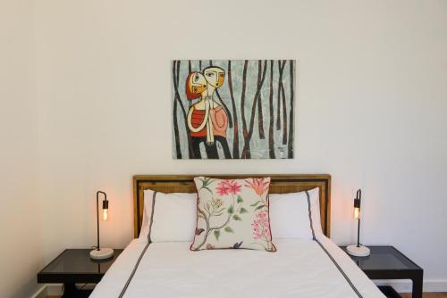 袋鼠谷Myrtle Tree Lodge Trunks - stand alone lodge in the Heart of village的一间卧室配有一张带两盏灯和一幅画的床铺