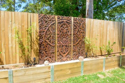 a wooden fence with a wooden carving on it at Myrtle Tree Lodge Trunks - stand alone lodge in the Heart of village in Kangaroo Valley
