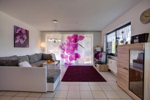 a living room with purple flowers on the wall at Ferienwohnung Seeblick in Schalkenmehren