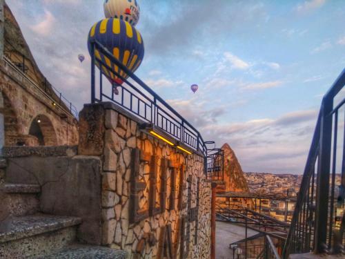 a building with hot air balloons in the sky at Elite Cave Suites in Goreme