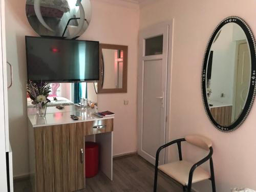 イズミールにあるInvivo Hotelの鏡付きの洗面台と椅子が備わる客室です。