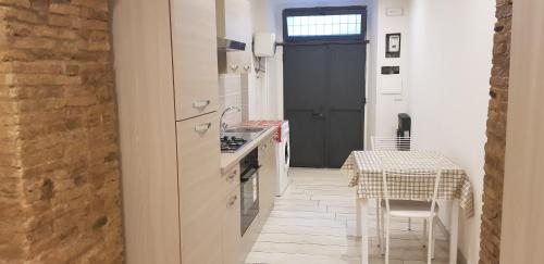 a kitchen with white cabinets and a table and a table and chairs at Janara - Santa Sofia in Benevento