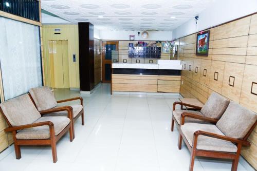 une chambre avec deux chaises et une cuisine dans l'établissement PRANAM COMFORTS LODGE, à Bangalore