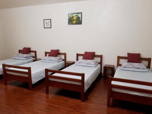 a group of four beds in a room at Minine Guesthouse in Silang