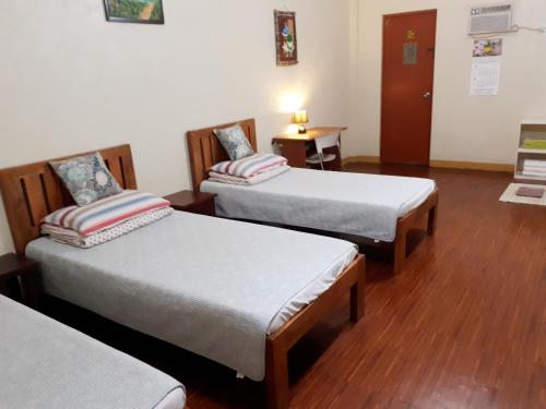 a hospital room with two beds and a table at Minine Guesthouse in Silang