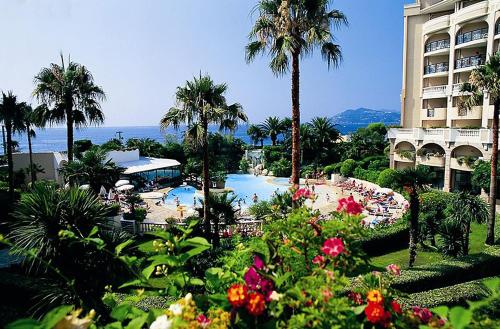 un complexe avec une piscine et un hôtel dans l'établissement Cannes, La Palme d'Or, à Cannes