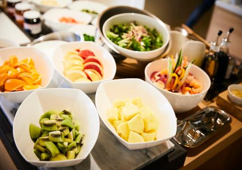 a table topped with bowls of different types of food at Hotel Intergate Kanazawa in Kanazawa