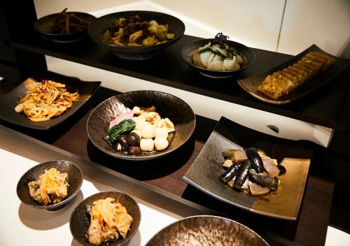 a bunch of bowls of food on a table at Hotel Intergate Kanazawa in Kanazawa
