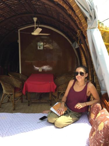a woman sitting on the floor in a hut at Thara's Houseboat in Alleppey