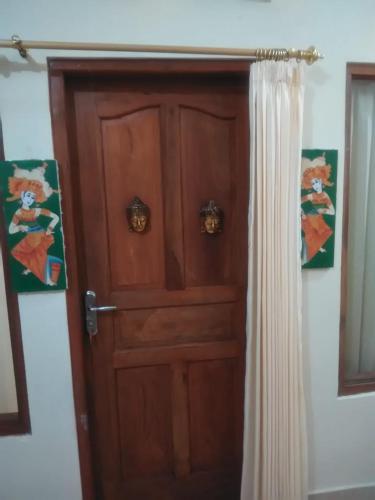 a wooden door in a room with a curtain at Made Roejas Family in Uluwatu