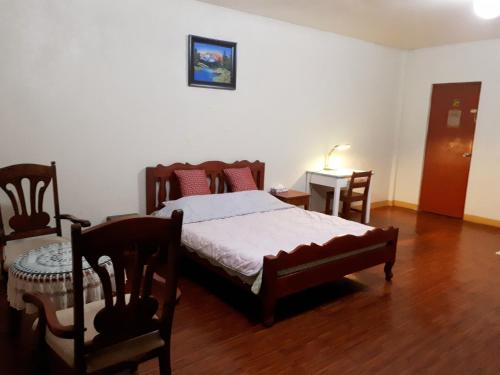 Schlafzimmer mit einem Bett, einem Tisch und Stühlen in der Unterkunft Minine Guesthouse in Silang