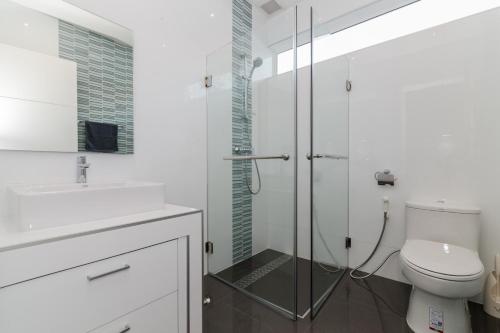 a bathroom with a toilet and a glass shower at Orchid Paradise Homes 404 in Hua Hin