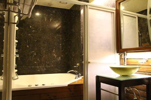 a bathroom with a bath tub and a sink at Constellation Coast B&B in Hualien City