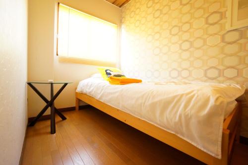 a small bedroom with a bed with a window at Tomato Takayama Station in Takayama