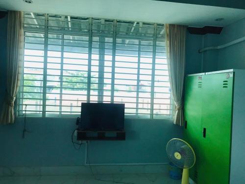 a room with a tv and a fan and a window at KampongBay Makeng II Guesthouse in Kampot