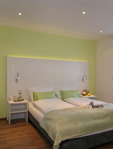 a bedroom with a large bed with green walls at Schlotzeria Hotel I Café I Eis in Grenzach-Wyhlen