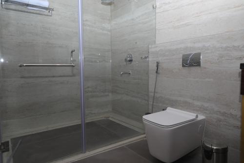 uma casa de banho com um WC e uma cabina de duche em vidro. em Visthara inn - Comfort Stay em Krishnagiri