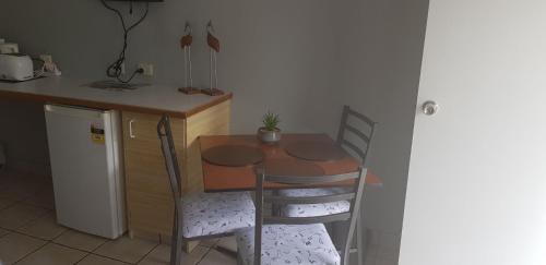 a small kitchen with a table and two chairs at Limassol Motel in Gold Coast
