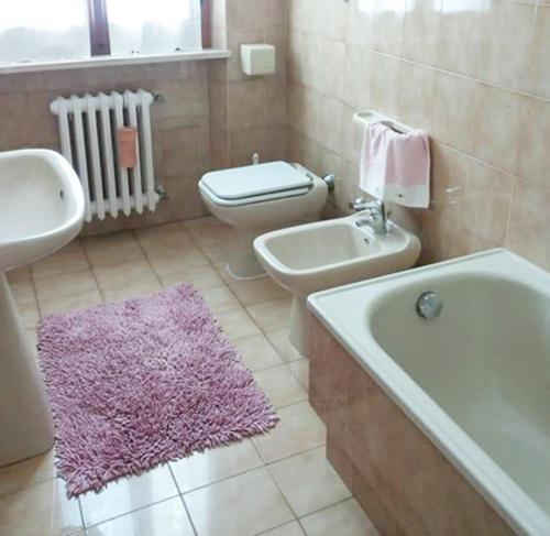 La salle de bains est pourvue d'une baignoire blanche, d'un lavabo et de toilettes. dans l'établissement la terrazza del silenzio, à Fattoria Spedaletto