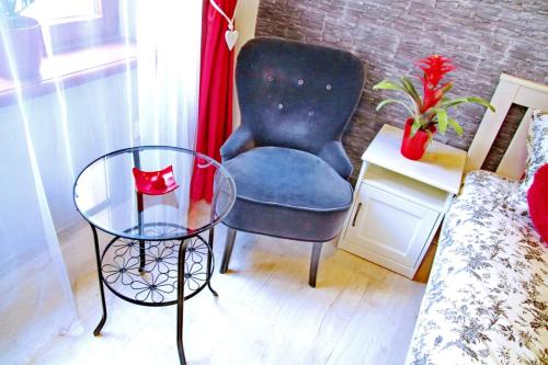 - une chambre avec une chaise et une table en verre dans l'établissement Grey Rooms, à Wrocław