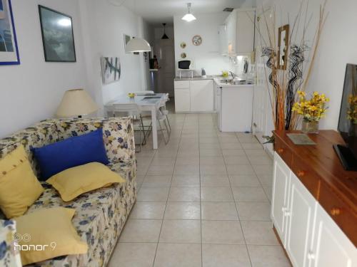 sala de estar con sofá y cocina en Casa Patrizia Playa San Juan, en Guía de Isora