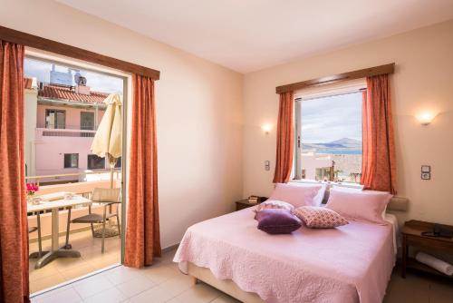 a bedroom with a bed and a large window at Mistrali Suites & Apartments in Kalyves