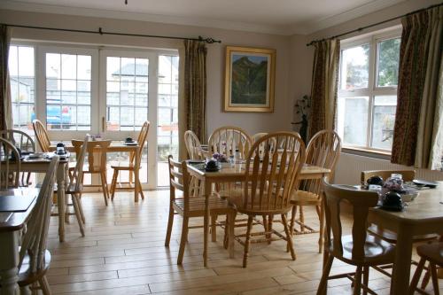 un comedor con mesas, sillas y ventanas en Celtic House B&B, en Kilkenny