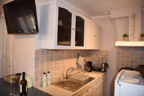 una cucina con lavello e microonde di Kampielo Apartment a Città di Corfù