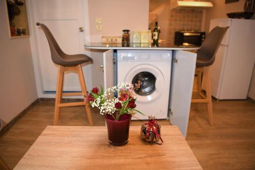 un vaso di fiori su un tavolo con lavatrice di Kampielo Apartment a Città di Corfù