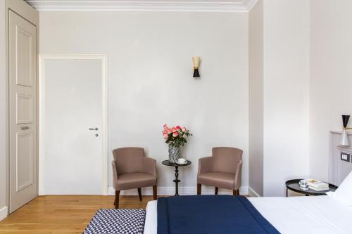 a bedroom with two chairs and a bed at Favilla Hotel di Charme in Rome