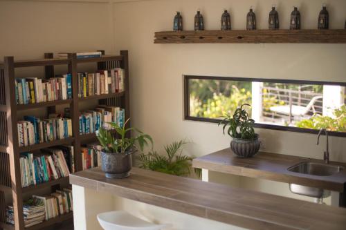 a kitchen with a sink and a book shelf with books at Ranis Lodge in Kampung Padang Masirat