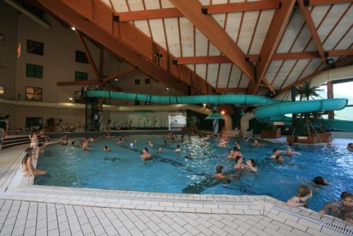 un groupe de personnes nageant dans une piscine dans l'établissement Villard-De-Lans - HyperCentre - Place de l'Ours (Libération) - 4 personnes, à Villard-de-Lans