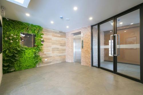 an empty lobby with a green wall and a door at The Home Hotel SHA in Bangkok