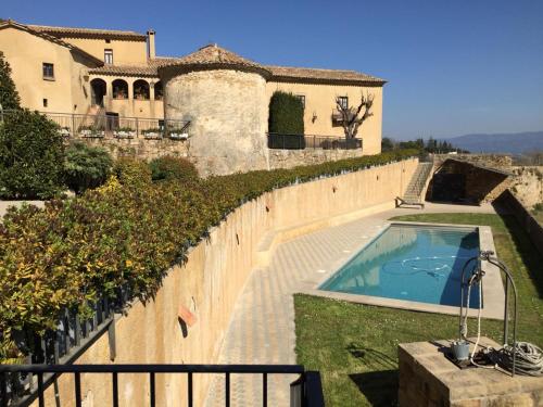 uma casa com uma piscina ao lado de uma cerca em Montserrat La Calsina em Monistrol