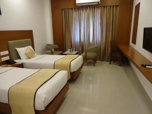 Postel nebo postele na pokoji v ubytování Hotel Park Residency Calicut